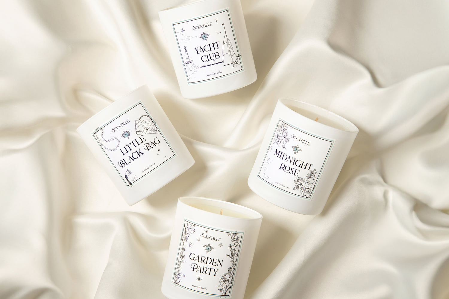 Four Scentille Candles lying down on silk