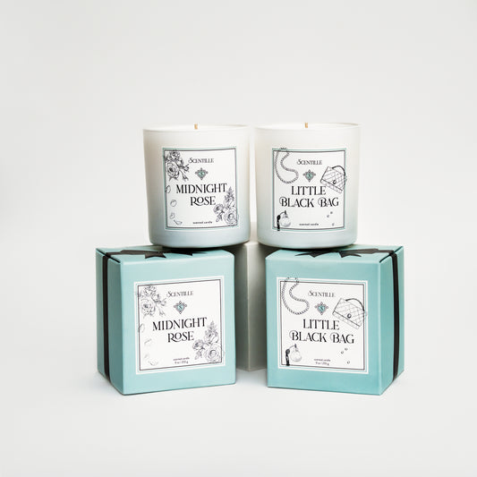 Two candles in boxes labeled 'Midnight Rose' and 'Little Black Bag' on a white background