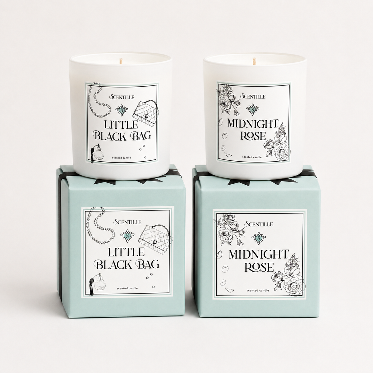 Two candles in boxes labeled 'Midnight Rose' and 'Little Black Bag' on a white background