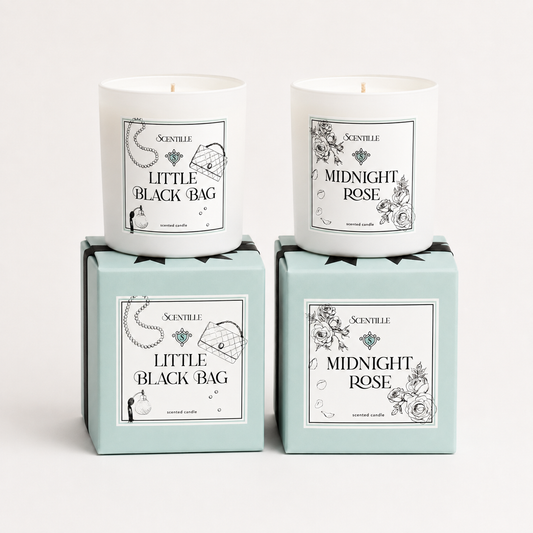 Two candles in boxes labeled 'Midnight Rose' and 'Little Black Bag' on a white background