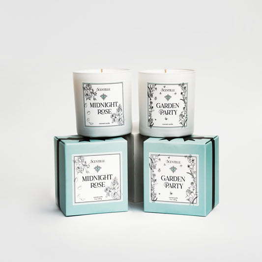 Two candles named 'Midnight Rose' and 'Garden Party' in their packaging on a white background.