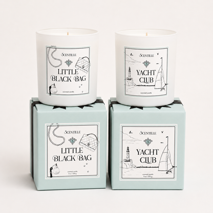 Two candles in boxes labeled 'Yacht Club' and 'Little Black Bag' on a white background