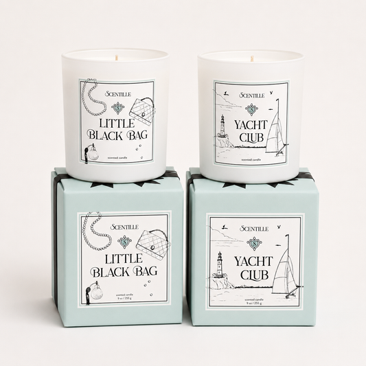 Two candles in boxes labeled 'Yacht Club' and 'Little Black Bag' on a white background