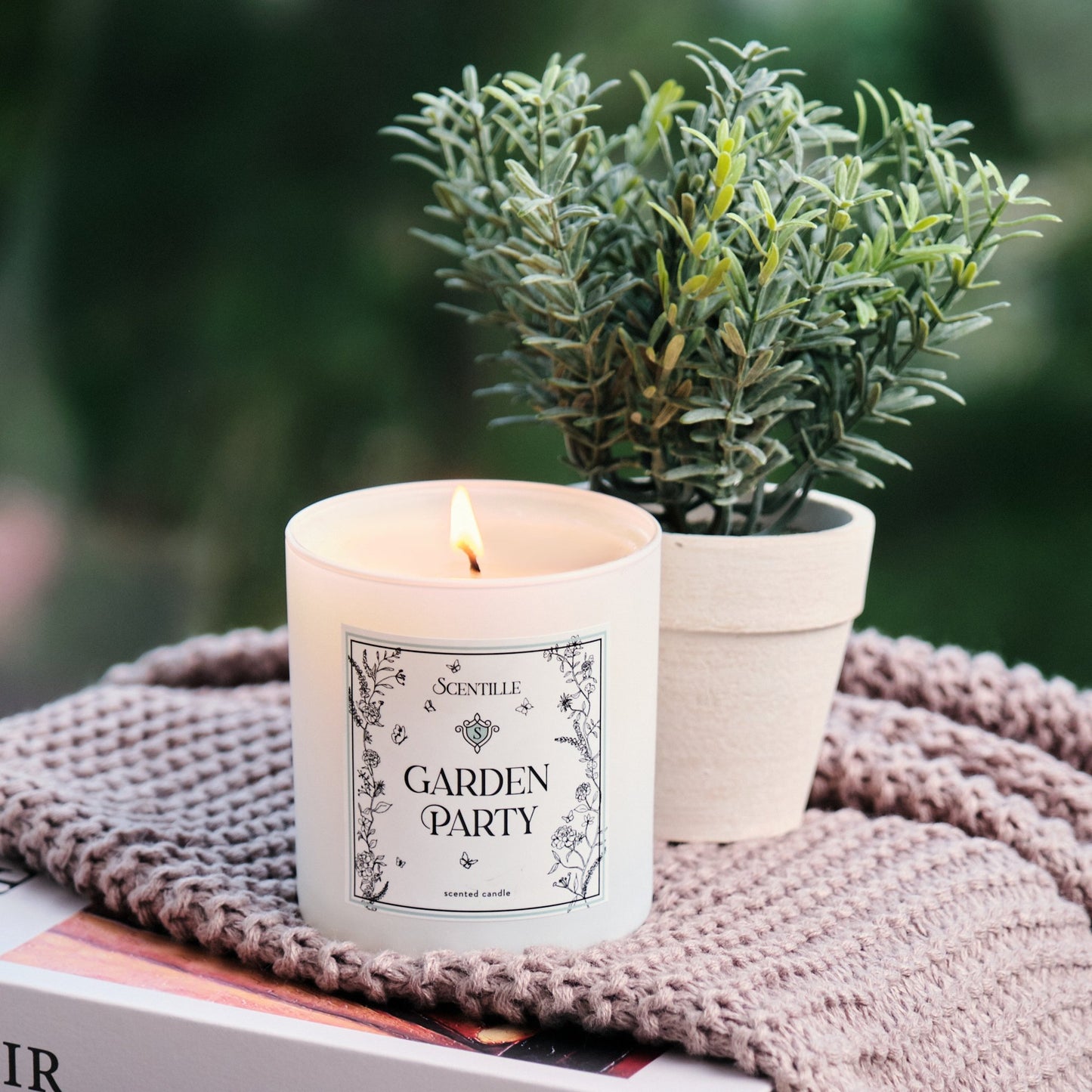 Garden Party candle next to a plan