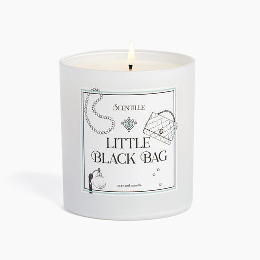 A lit Little Black Bag candle from Scentille