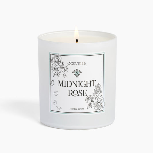 A lit Midnight Rose candle from Scentille