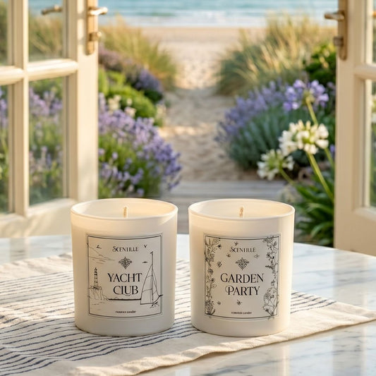 Two candles labeled 'Yacht Club' and 'Garden Party' on a table with a beach view in the background.